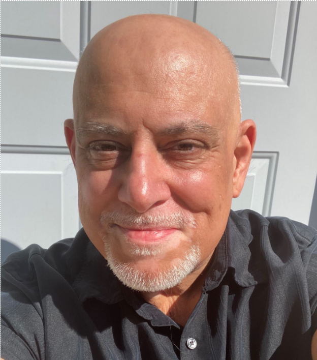 NeibaurHeadshot Bald Caucasion Male with white stubble smiling