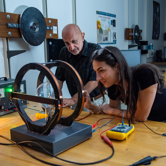 Image of a student and a professor working on a physics project/research
