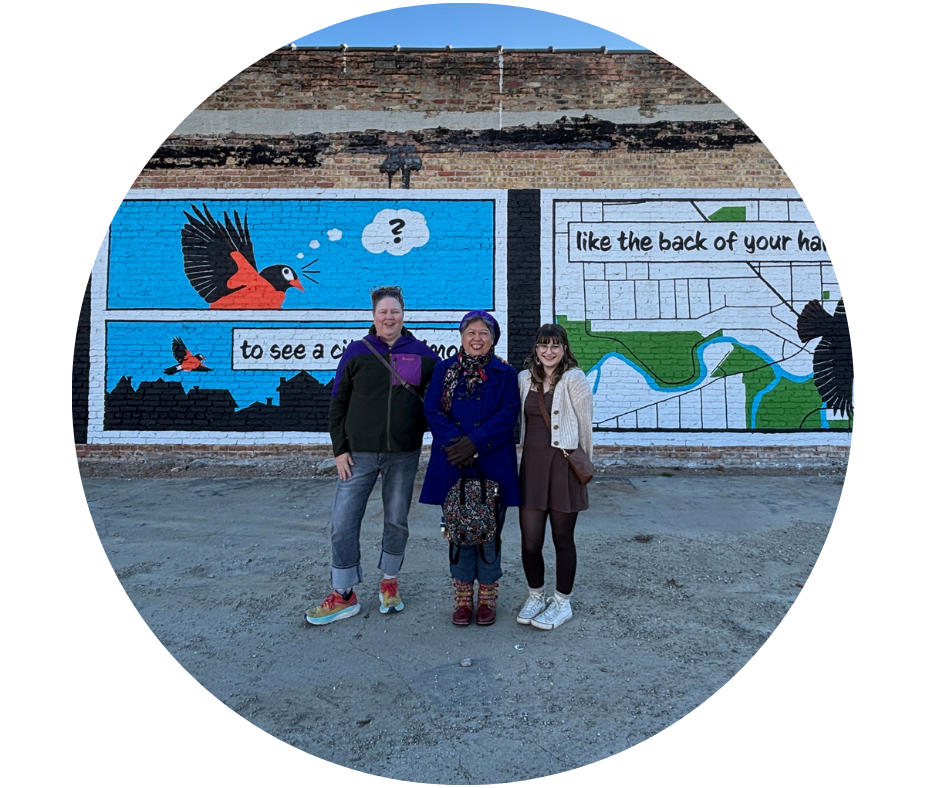 Photo of 3 people standing in front of murals for the ArtRoot Wall Poems of Racine Project