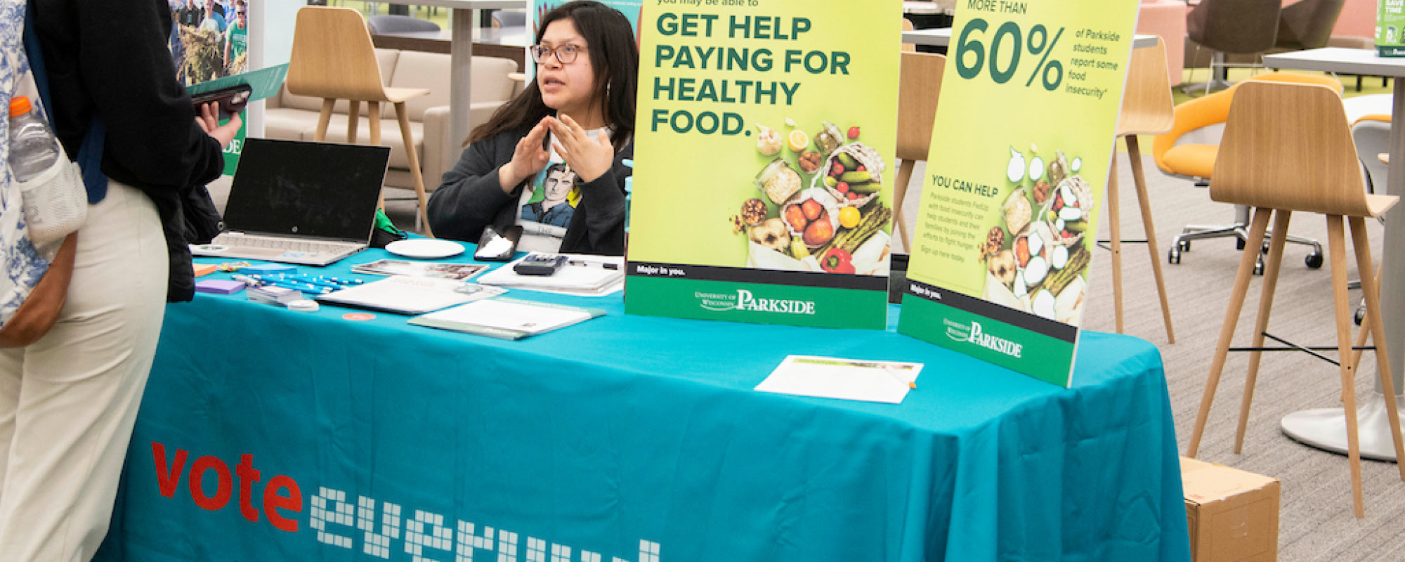 Student helping at a vote everywhere table