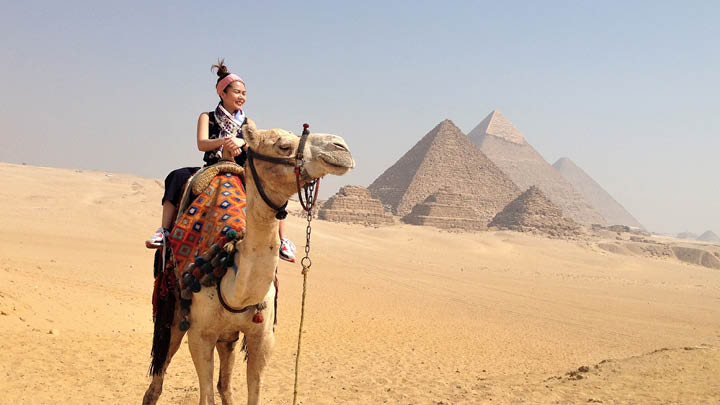 Young woman in desert on a camel