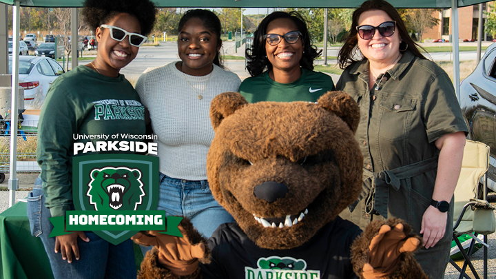 Homecoming logo with group of alumni and ranger bear smiling