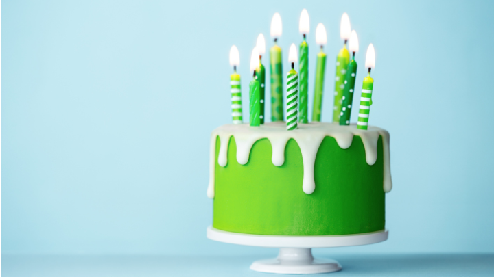 Green cake with candles on a blue background