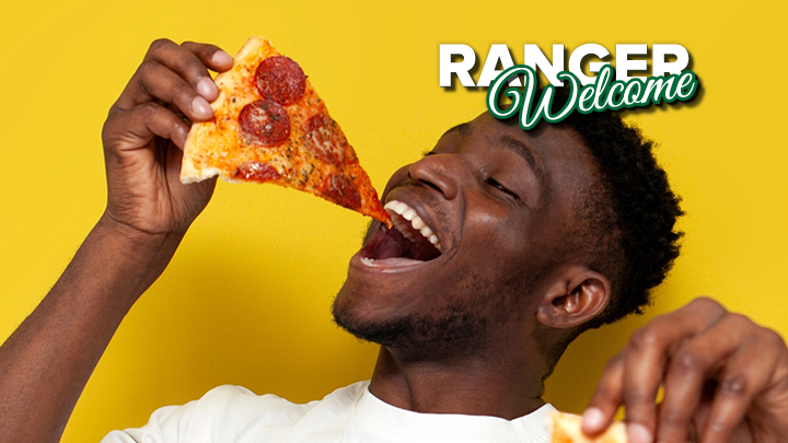 Image of a young man taking a bit of a pepperoni pizza slice, image background is yellow