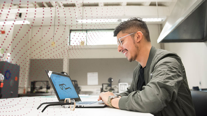 Image of a man at his laptop creating in a tech environment
