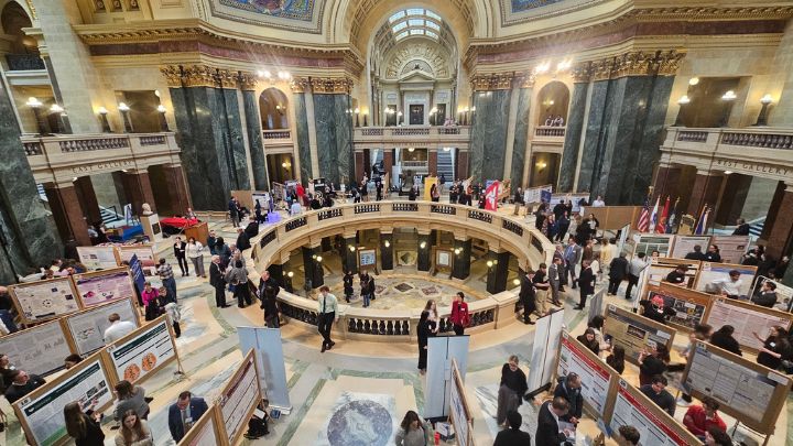 Wide shot of the rotunda of the Wisconsin State Capitol where students are presenting research