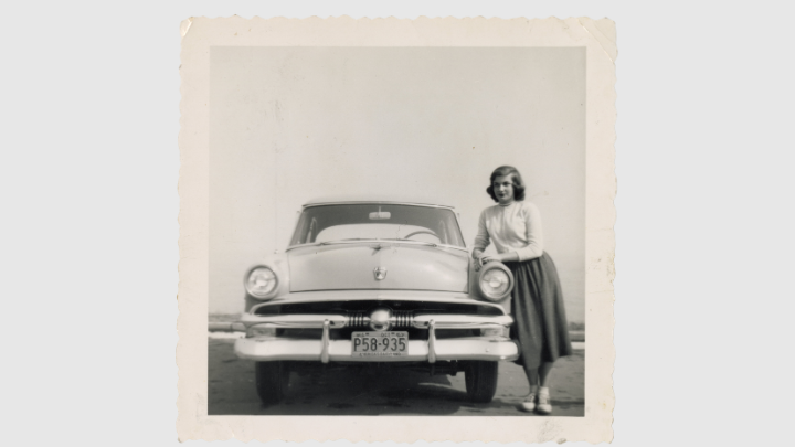 Woman standing next to car