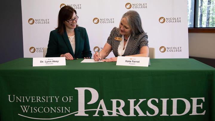 Chancellor Akey and President Ferrel sign the agreements