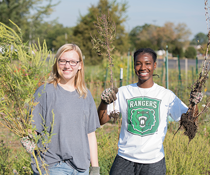 Two female Parkside students pulling weeds at Garden of Eatin