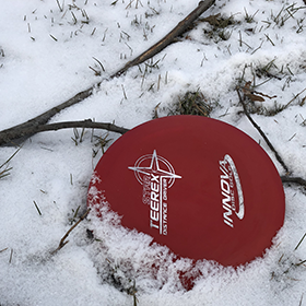 Red disc golf disc in the snow