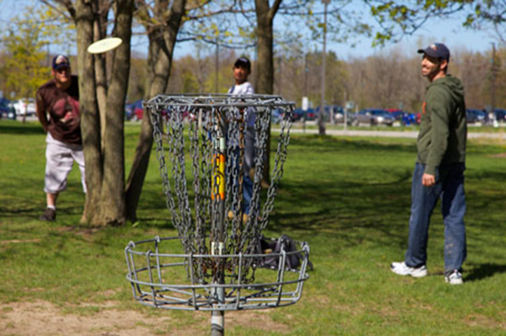 Three Guys Playing Disc Golf