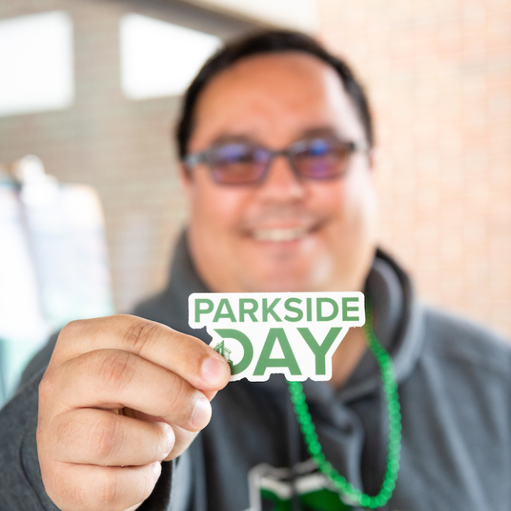 Man presenting Parkside Day sticker