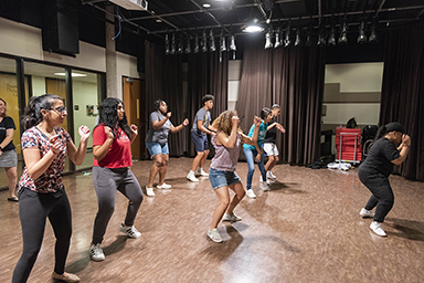 Students learning hip hop moves from dance instructor Kira Hogan