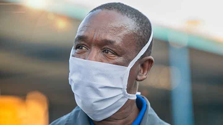 African American man arrives to work wearing a mask