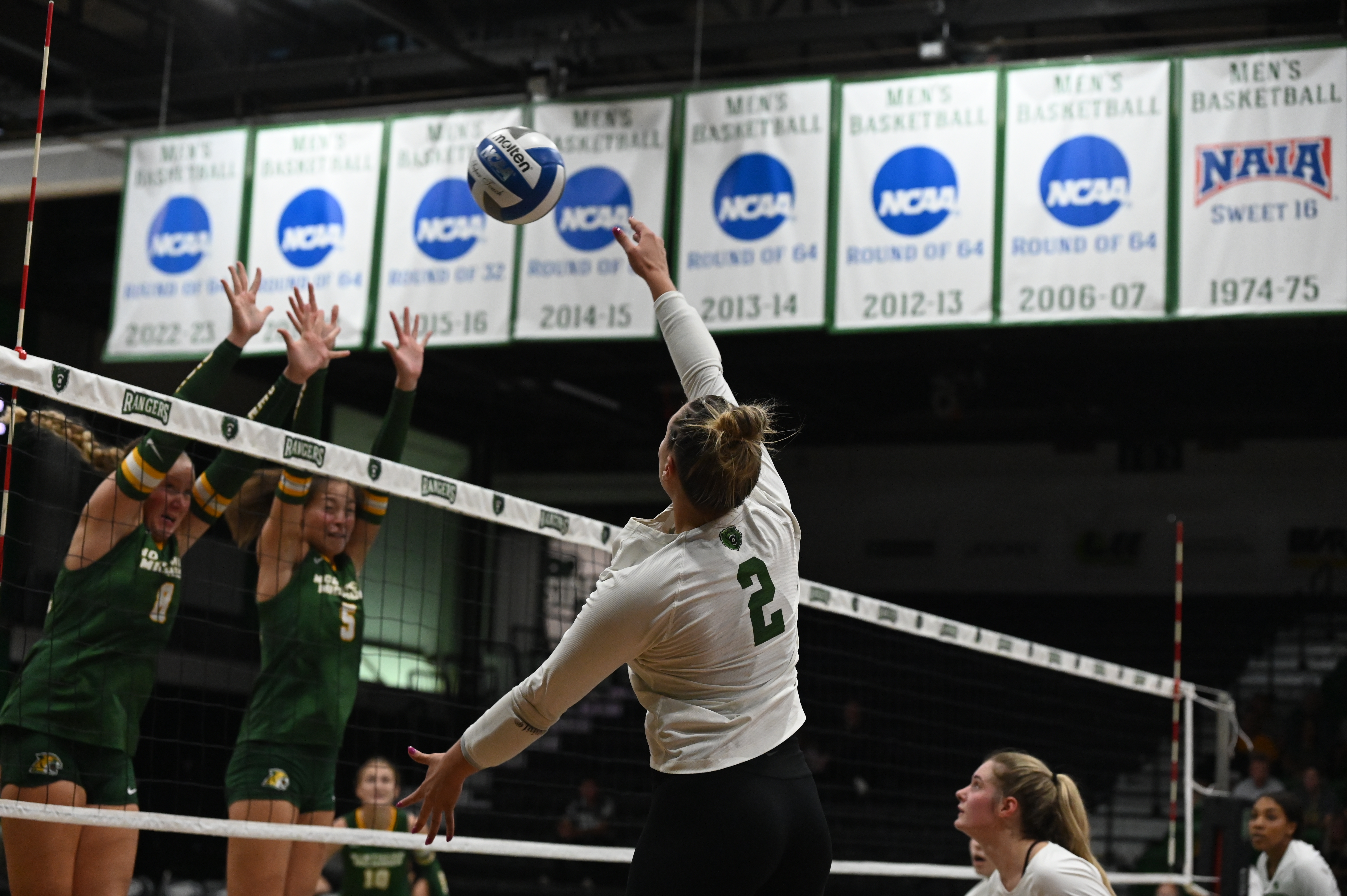 Ranger volleyball. player spiking the ball over the net.