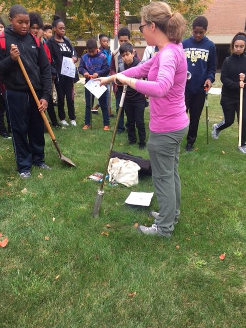 Laura Schulz showing students how to dig into the ground.