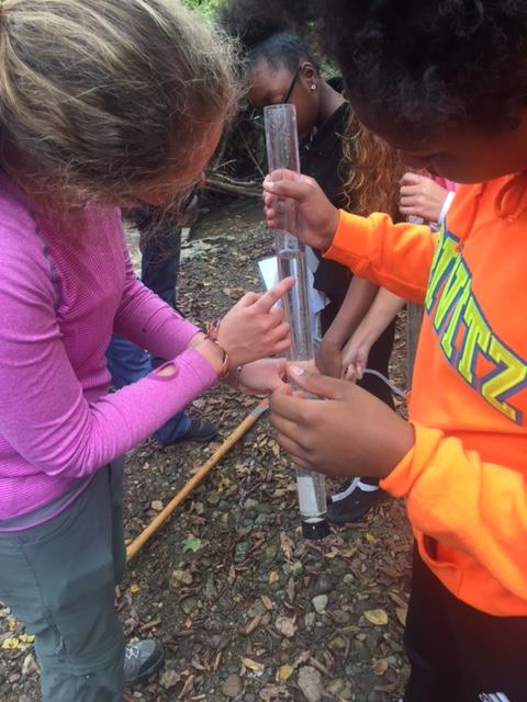 Laura Schulz helps student measure water levels.