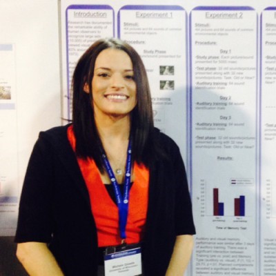 Image of Michele standing in front of a research poster
