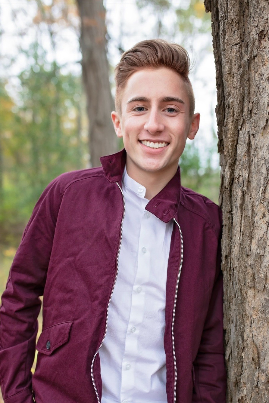 an image of thomas schraut leaning against a tree