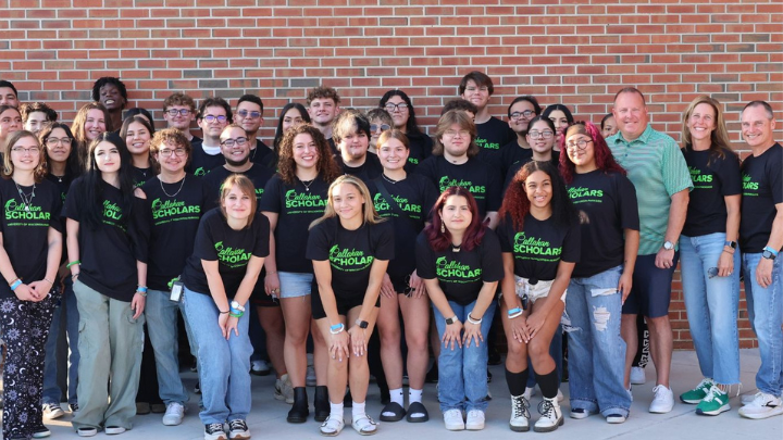 Callahan Palmer Photo A large group of students and staff pose together in front of a brick wall, with many wearing matching black Callahan Scholars t-shirts.