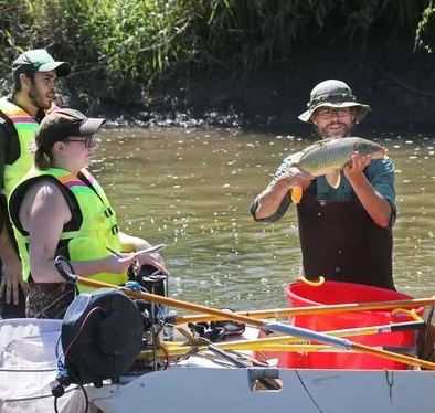 UW-Parkside students sampling water from the Root River