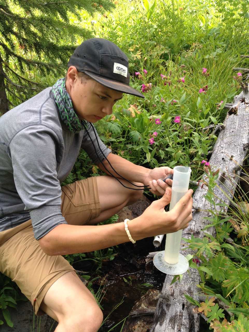 UW-Parkside student samples water from Root River