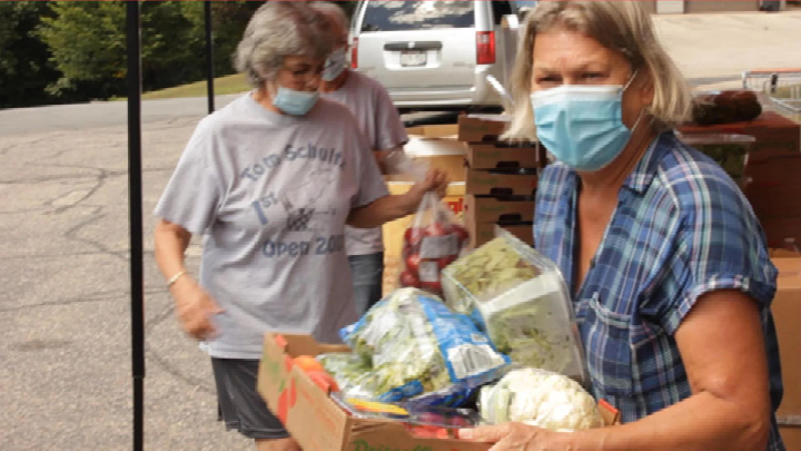 people with masks during pandemic running a food drive boxes of food