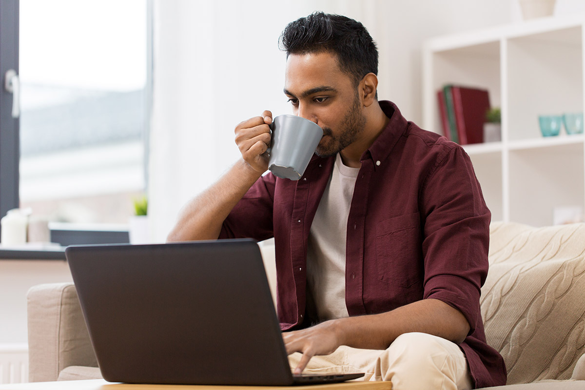 shutterstock_775495900 person drinking coffee at laptop