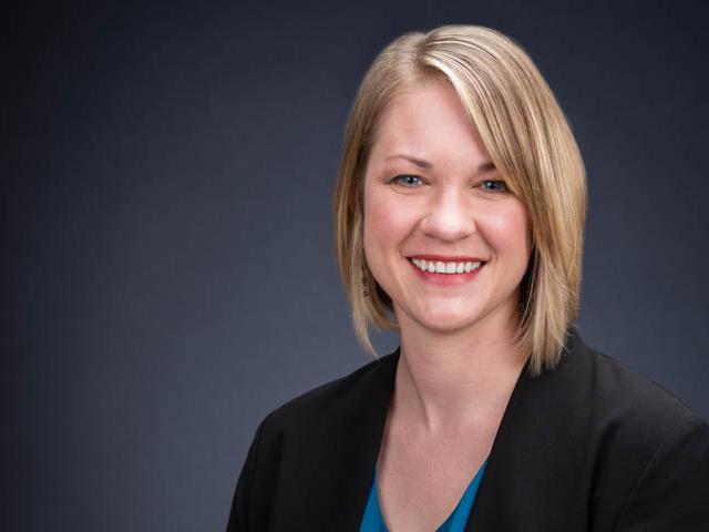 Photo of blonde woman smiling and wearing suit jacket