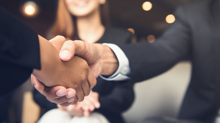 Image depicts two people shaking hands