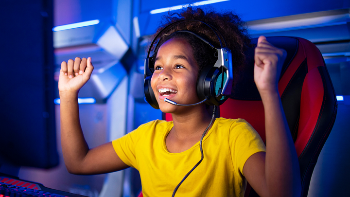 Image depicts a child gaming on a computer