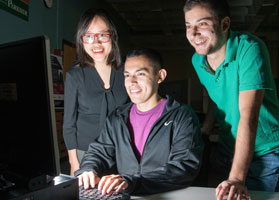 Three computer science majors looking at monitor