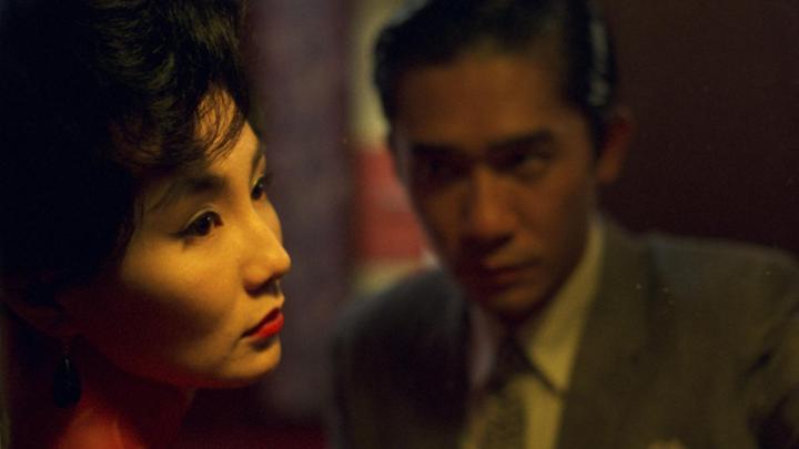 A woman looks off to the right and a man stands out of focus next to her staring at her