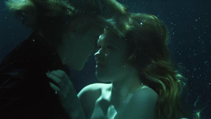 Two people underwater looking at each other