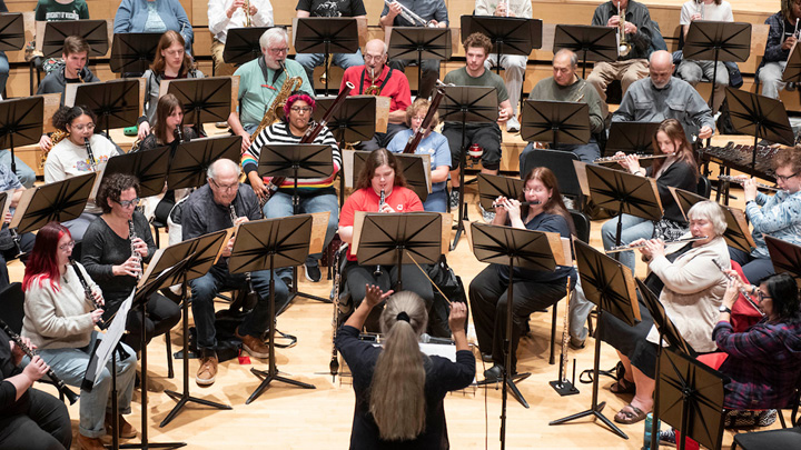 Conductor conducting orchestra in Bedford Hall