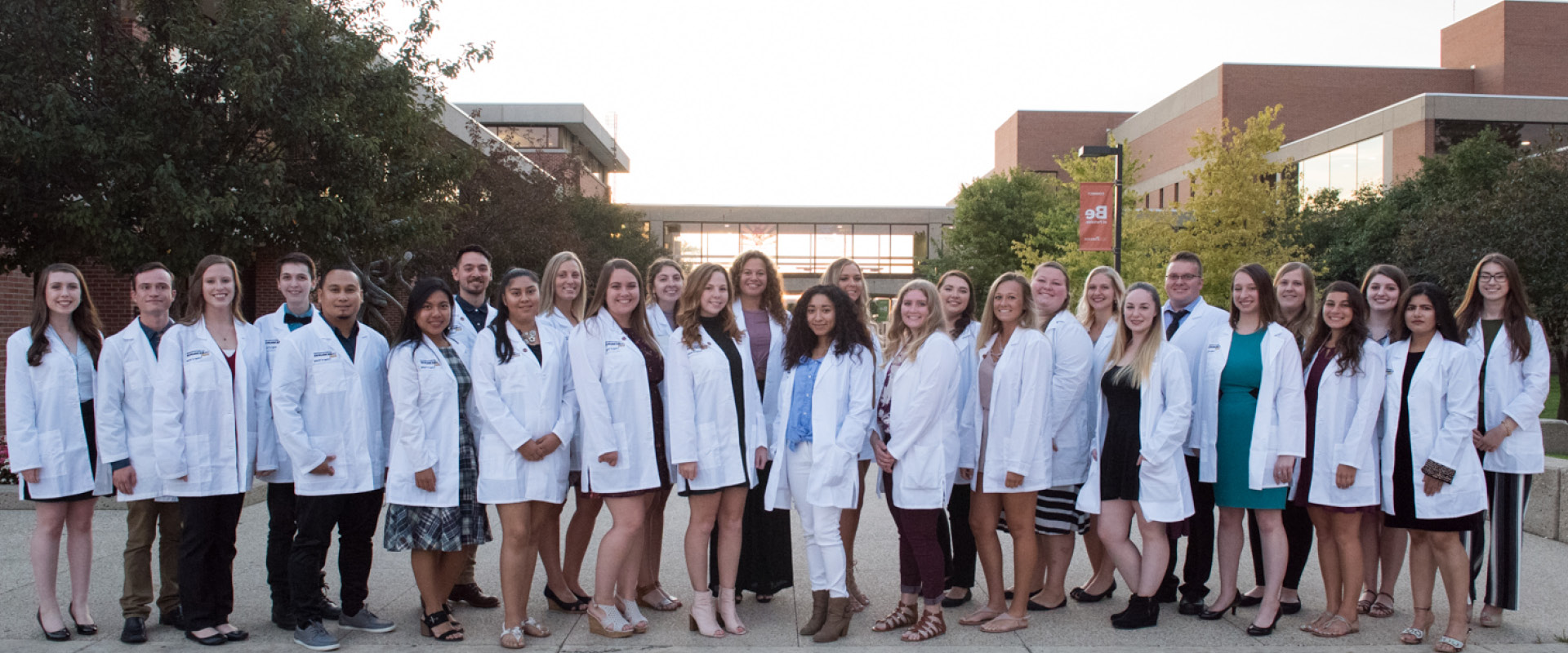 A group photo of UWP Nursing Program graduates wearing their white coats.