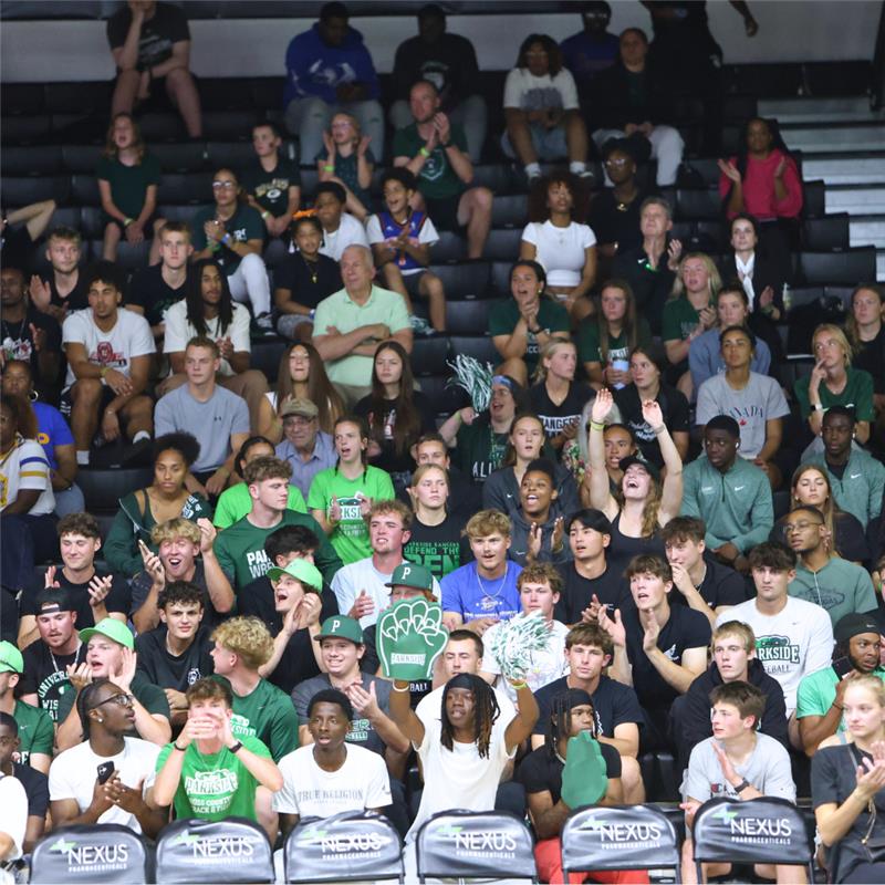 A crowd in the bleachers at a volleyball game during homecoming.