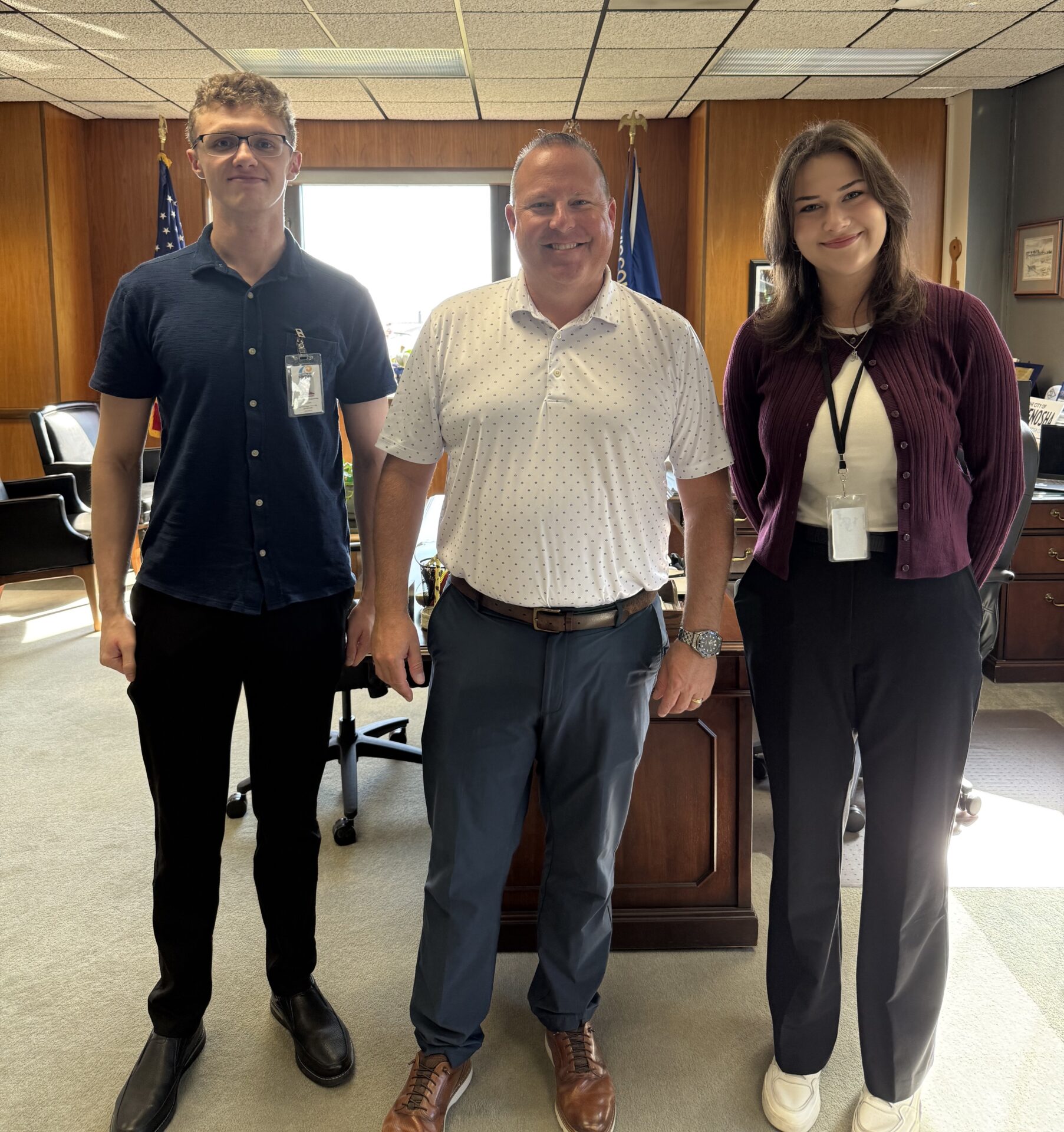 Two University of Wisconsin Parkside students stand with Kenosha Mayor David Bogdala as they begin their internships with the City of Kenosha.
