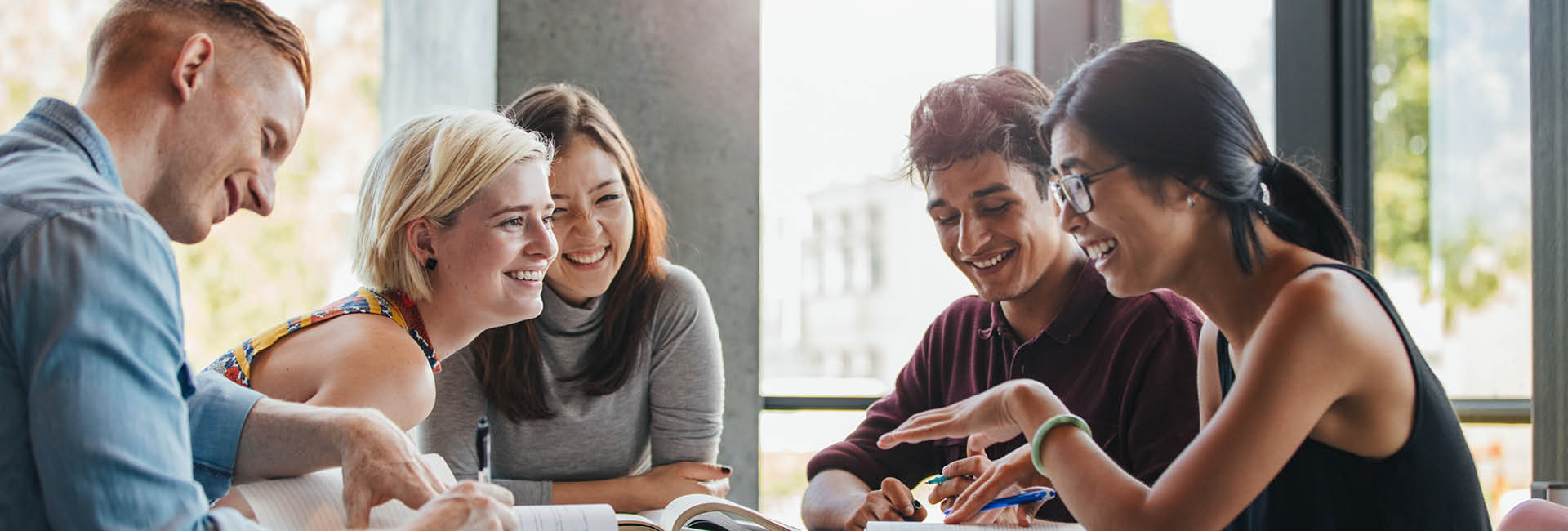 5 People sitting around laughing while studying.