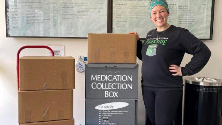 Officer posing with a Medication Collection box for National Drug Prescription Take Back Day.