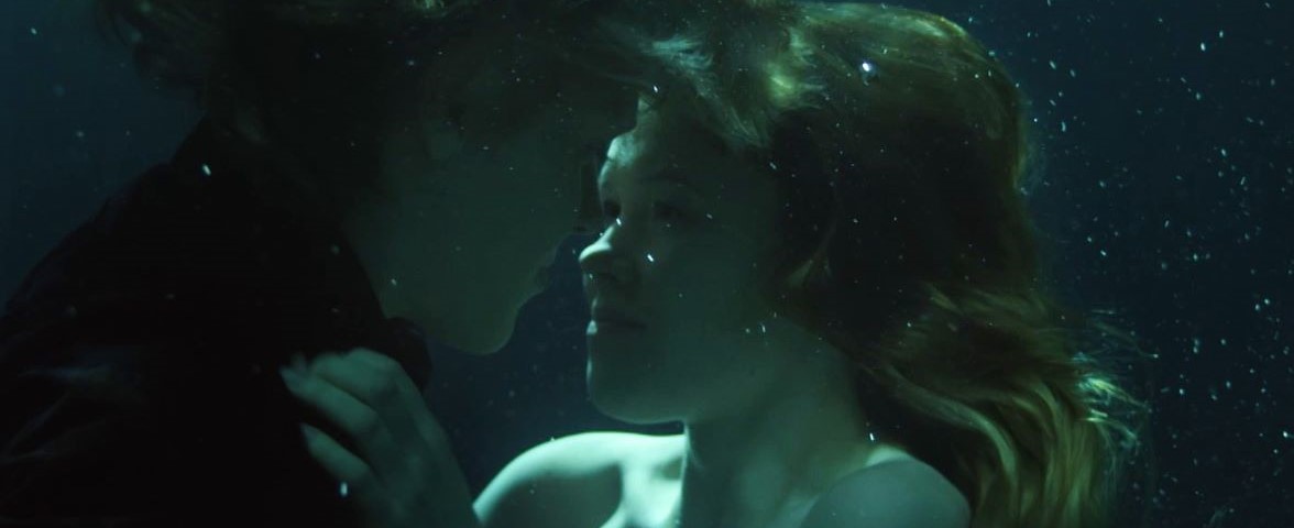 Two people underwater looking at each other