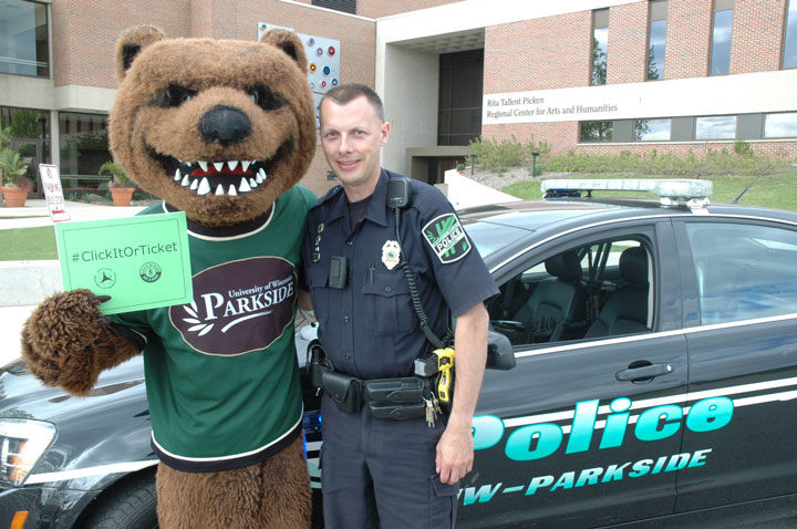 Ranger Bear and Officer Moeller posing in front of a UW-Parkside police car