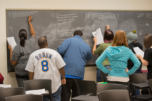 An English class taught by Associate Professor Dana Oswald discusses the style of an essay written about the epic poem Beowolf.