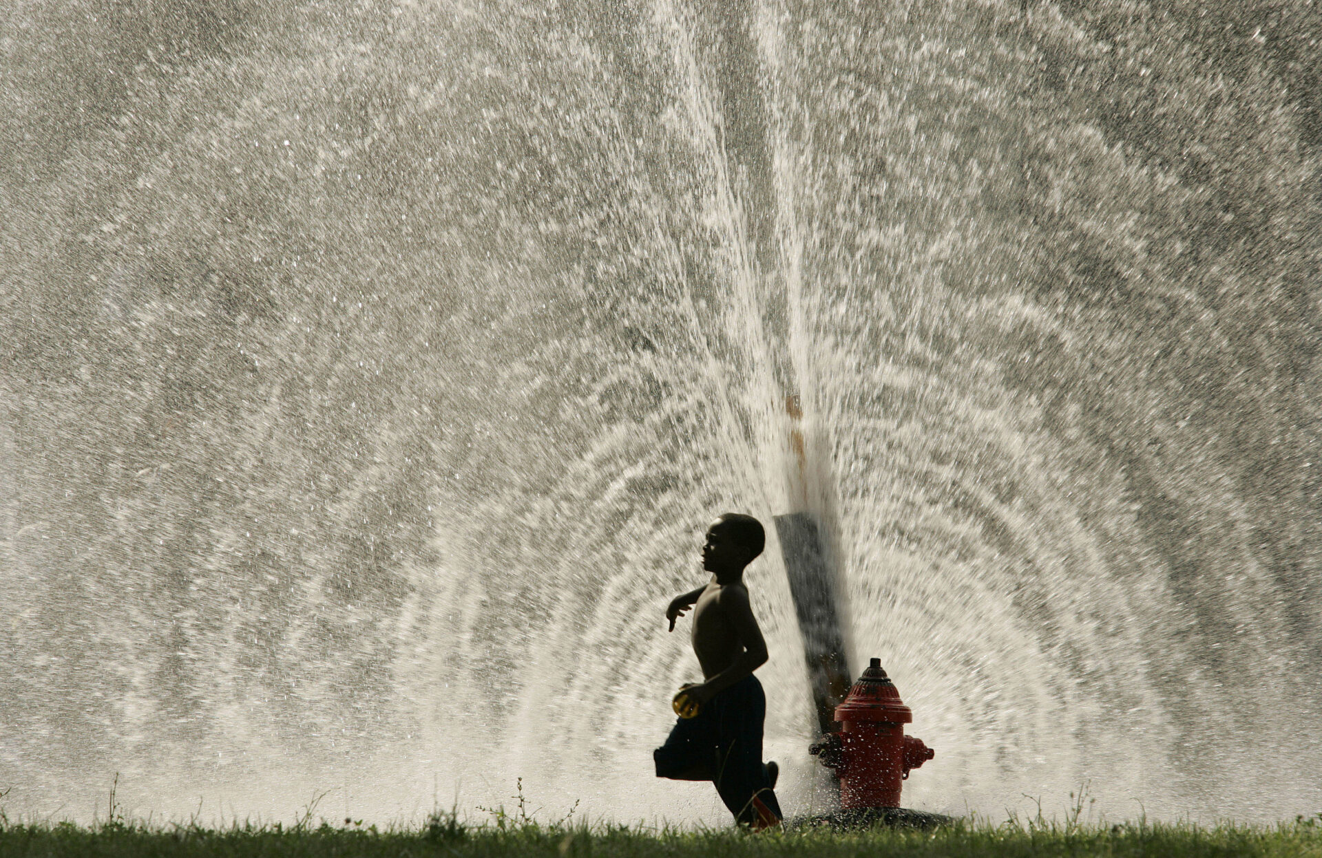 Photo by Al Fredrickson: Boy prances through summer fire hydrant spray. Light crystallizes magically through a water cascade “A boy runs past spray from an illegally opened fire hydrant in Milwaukee, Wisconsin as people seek relief from a heat wave.